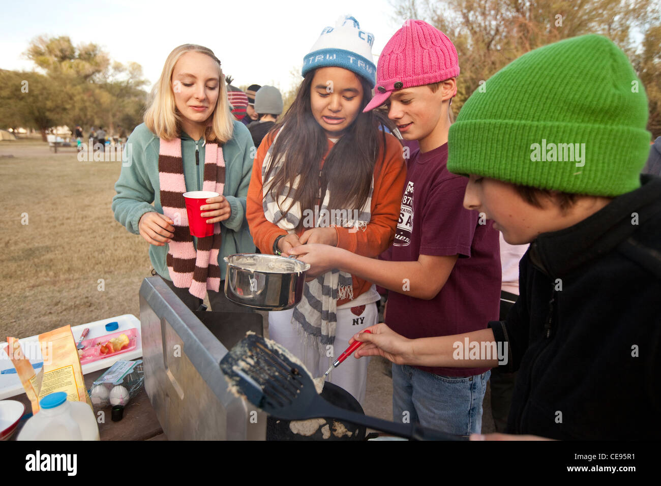 Mittelschule Klassenfahrt zum Big Bend National Park in Texas. Studenten kochen Frühstück mit Pfannkuchen in einem camp Stil Herd Stockfoto