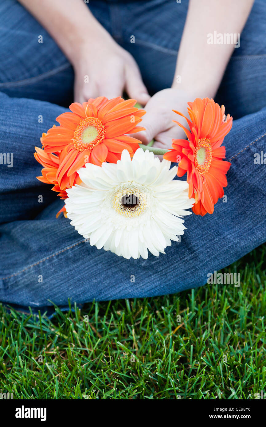 USA, Illinois, Metamora, Nahaufnahme junge Frau sitzt auf dem Rasen, mit Blumen Stockfoto