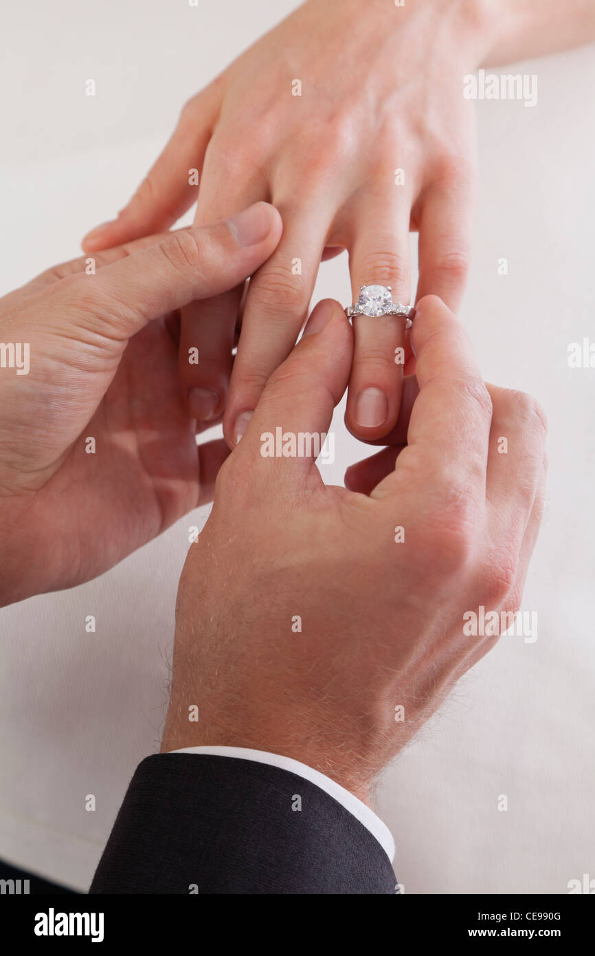 Nahaufnahme des Bräutigams Hand Braut Finger Ring aufsetzen Stockfoto