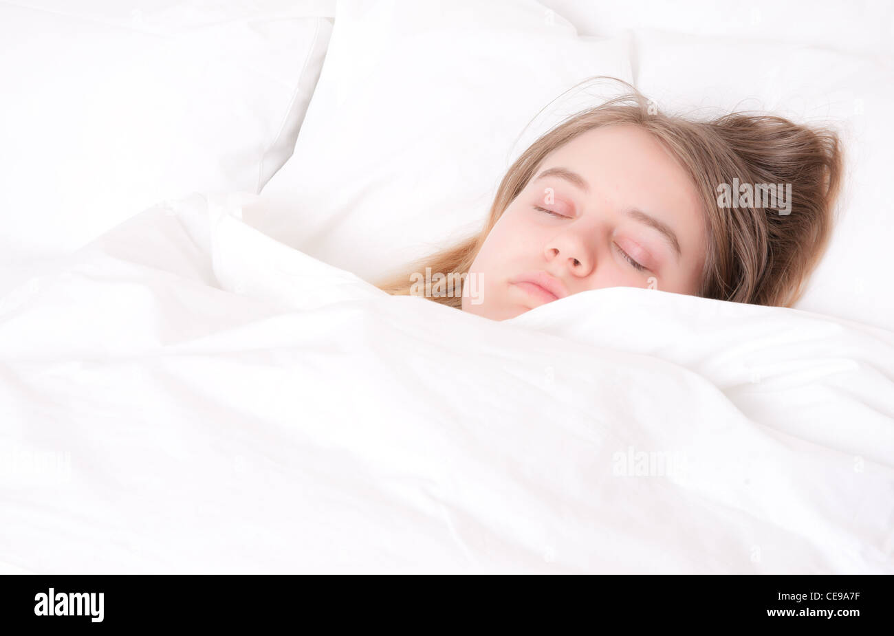 eine junge Frau in ihrem Bett schlafen Stockfoto