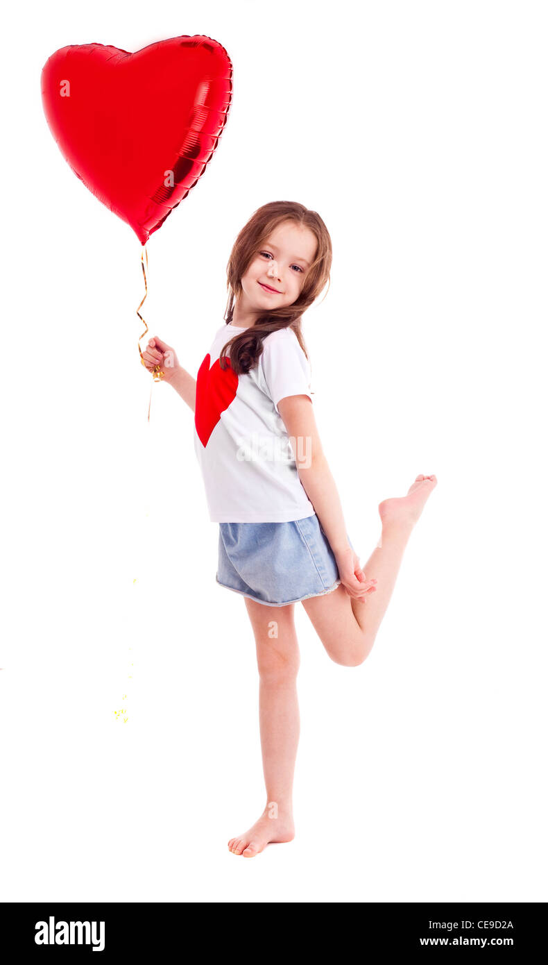 niedliche sechs Jahre alten Mädchen trägt ein T-shirt mit einem großen roten Herz auf weißen Hintergrund isoliert Stockfoto