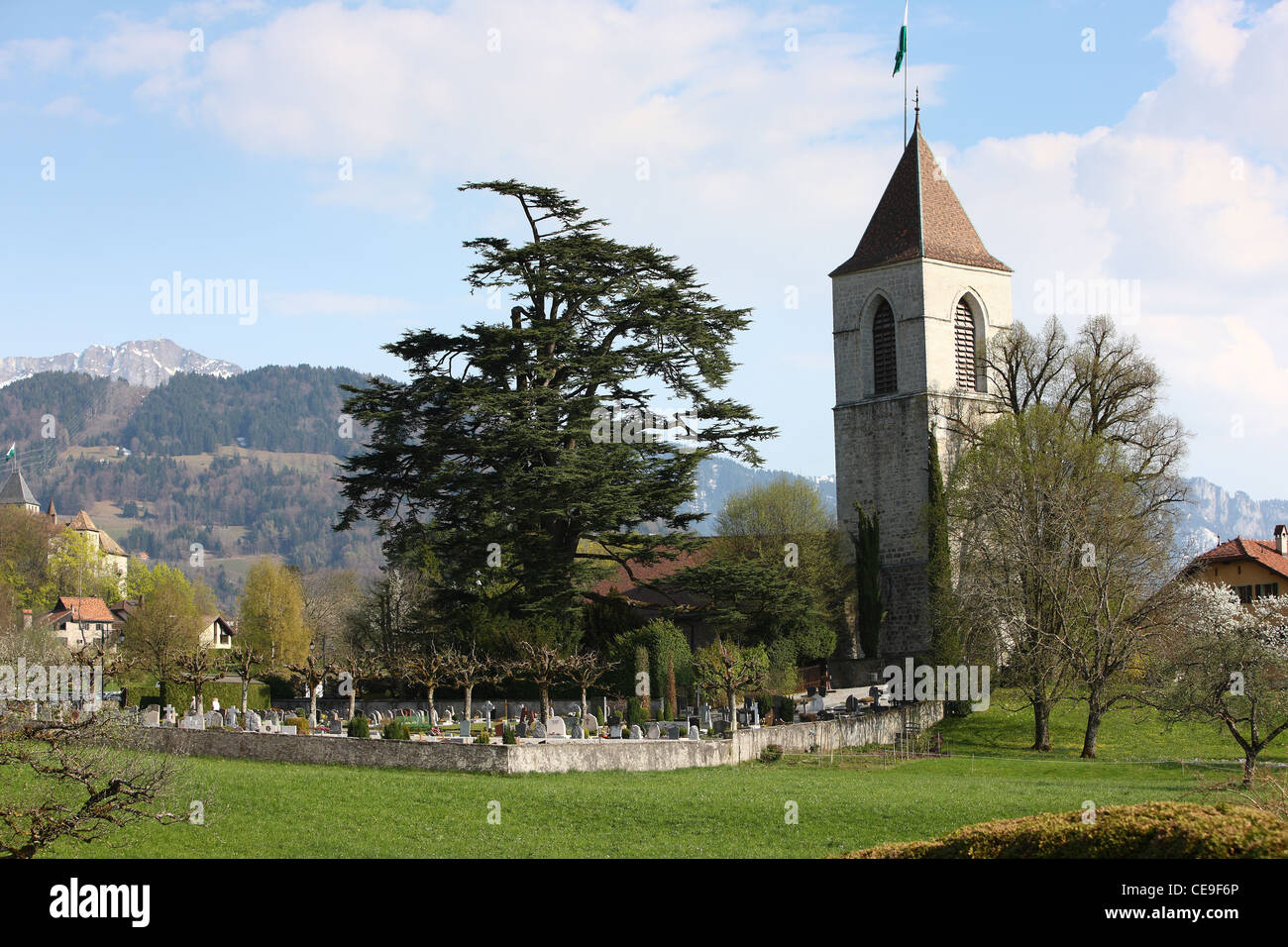 Blick auf die Kirche und der Friedhof auf den Steingarten. Im Hintergrund sind die Gipfel der Alpen. Frühling in der Schweiz. Stockfoto