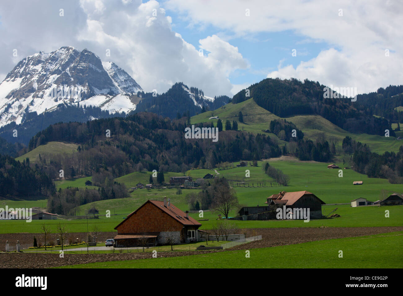 Häuser im Tal in den Schweizer Alpen. Blick vom Hügel im Dorf von Greyerz. Im Hintergrund ist der schneebedeckte Gipfel. Stockfoto