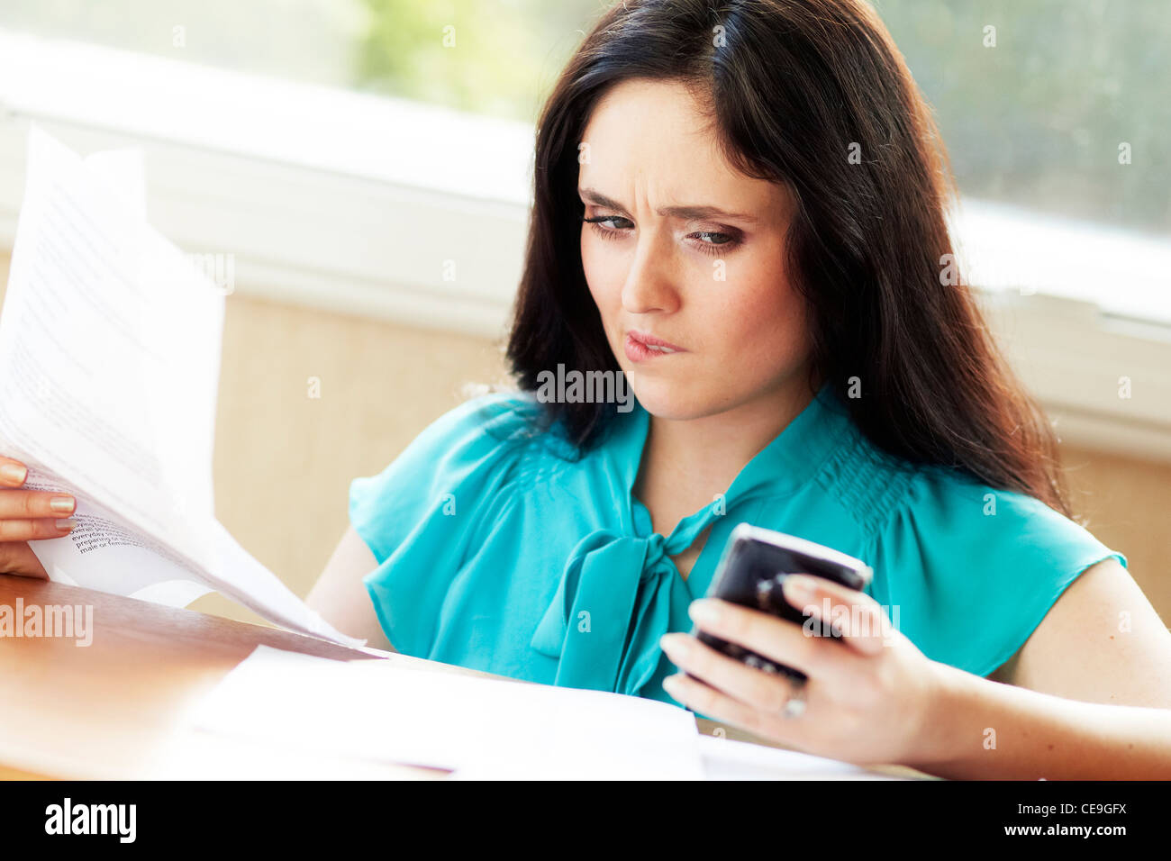 Frau mit Handy-Rechnungen Stockfoto