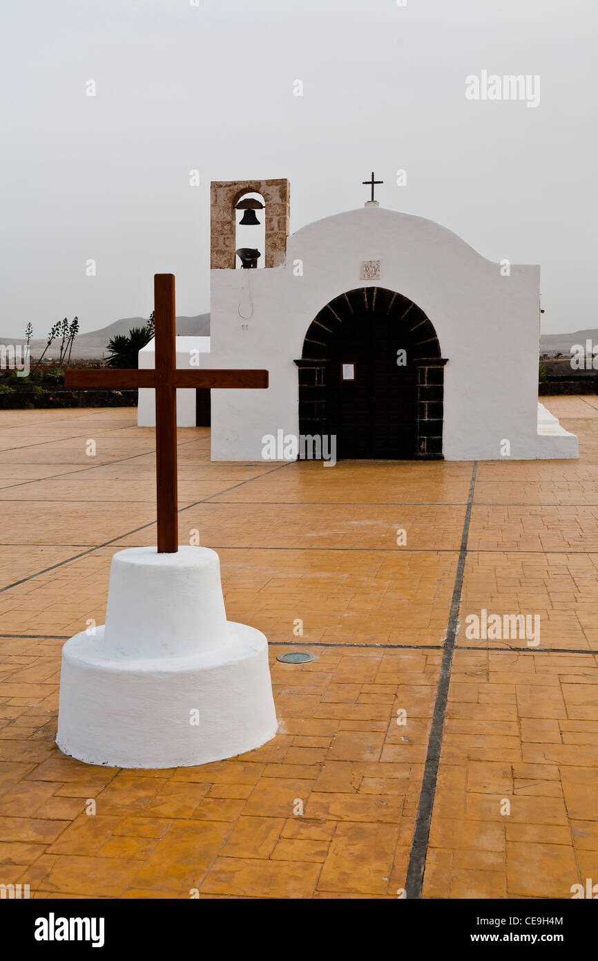 Eine kleine Kirche, mit einem Kreuz im Vordergrund. El Cotillo, Fuerteventura, Spanien. Stockfoto