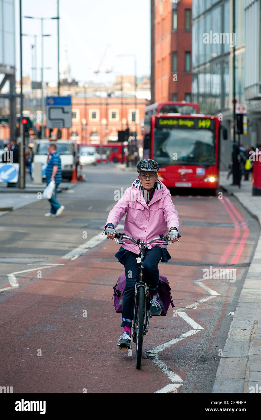 Lady Radfahren eine rote Route in der Mitte der Stadt von London, England. Stockfoto