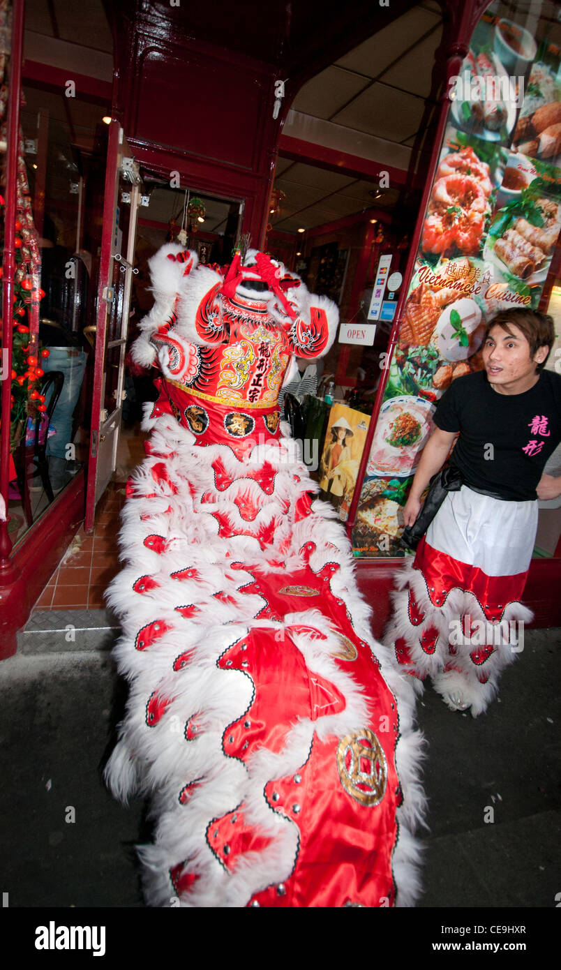Chinese New Year Tradition wo Löwen Marionette Resta Lebensmittel mit roten Umschlag mit Geld (symbolisiert Glück) gespeist wird Stockfoto
