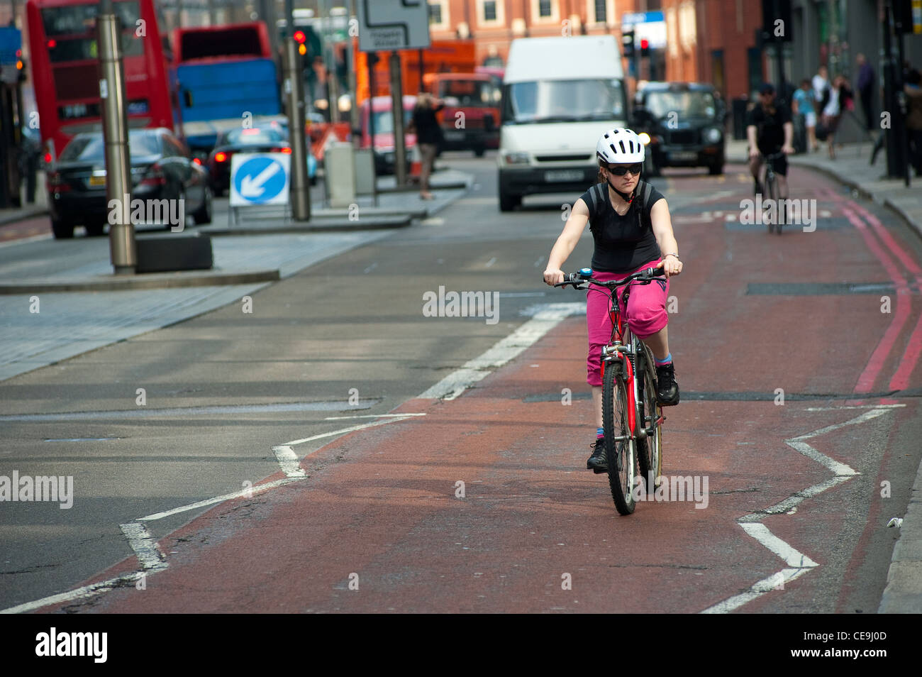 Lady Radfahren eine rote Route in der Mitte der Stadt von London, England. Stockfoto