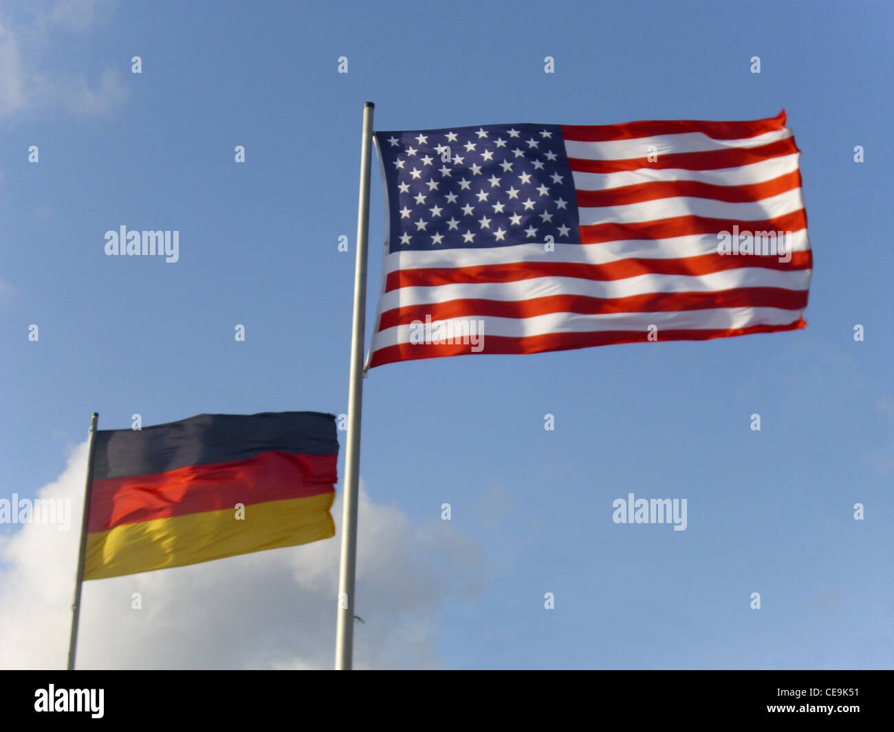 Die Fahnen der Vereinigten Staaten und Deutschlands symbolisieren die diplomatischen Beziehungen und gemeinsamen Werte zwischen den beiden Nationen. Die US-Flagge ist mit dreizehn Streifen und fünfzig Sternen versehen, die ihre bundesstaaten repräsentieren, während die deutsche Flagge aus horizontalen schwarzen, roten und goldenen Bändern besteht, die ihre nationalen Farben widerspiegeln. Stockfoto