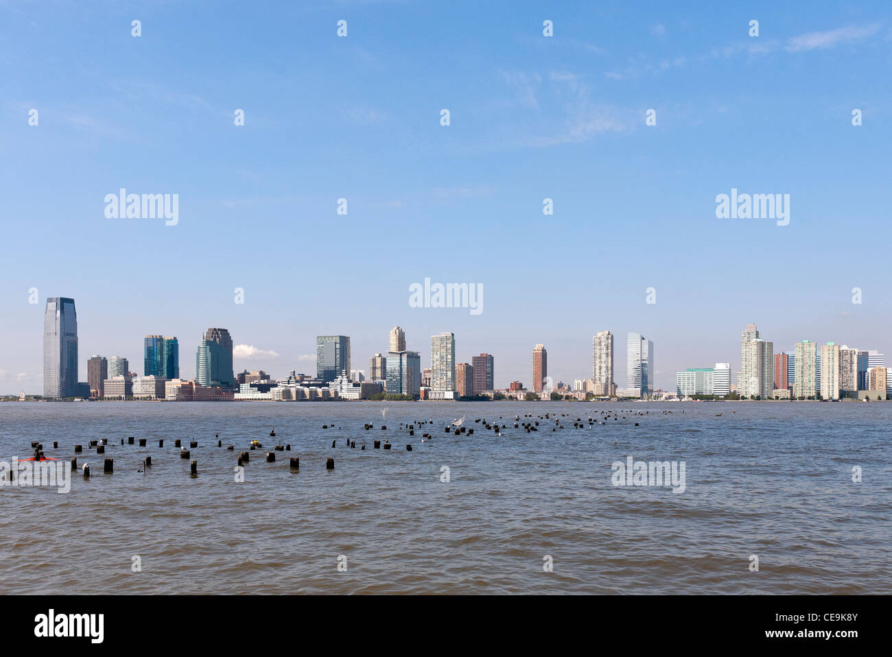 Ein Blick auf die Skyline von Jersey City, New Jersey aus über den Hudson River und New York City Pier 25. Stockfoto
