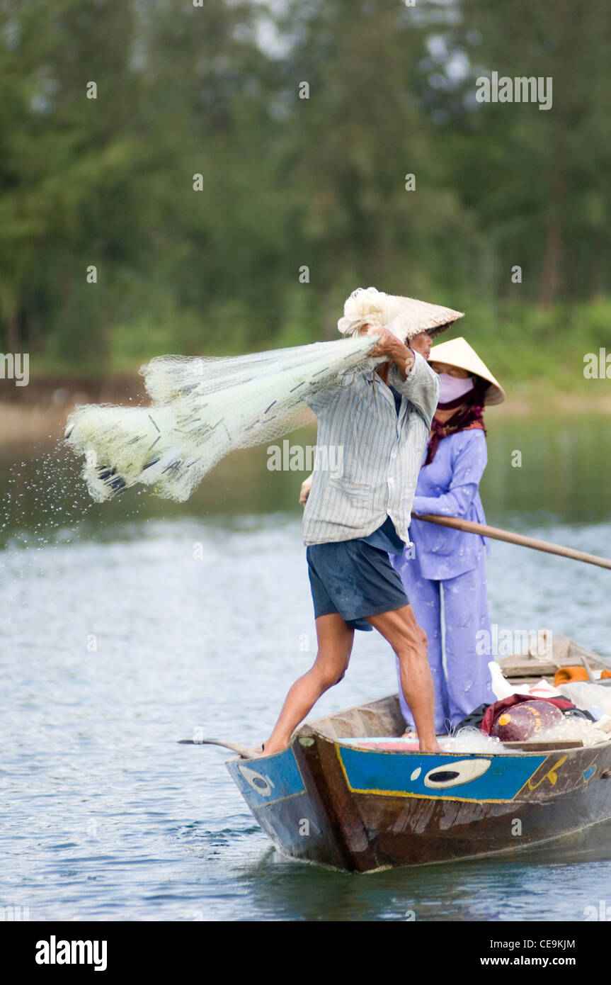 Ein Fischer schwingt seine große gewichteten netto um seinen Kopf und in den Gewässern des Flusses Thu Bon in der Nähe von Hoi an in Vietnam. Stockfoto