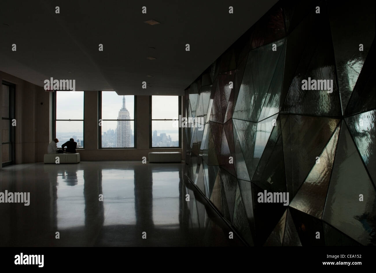 Touristen genießen einen Blick auf das Empire State Building aus dem Rockefeller Center, New York, USA. Stockfoto