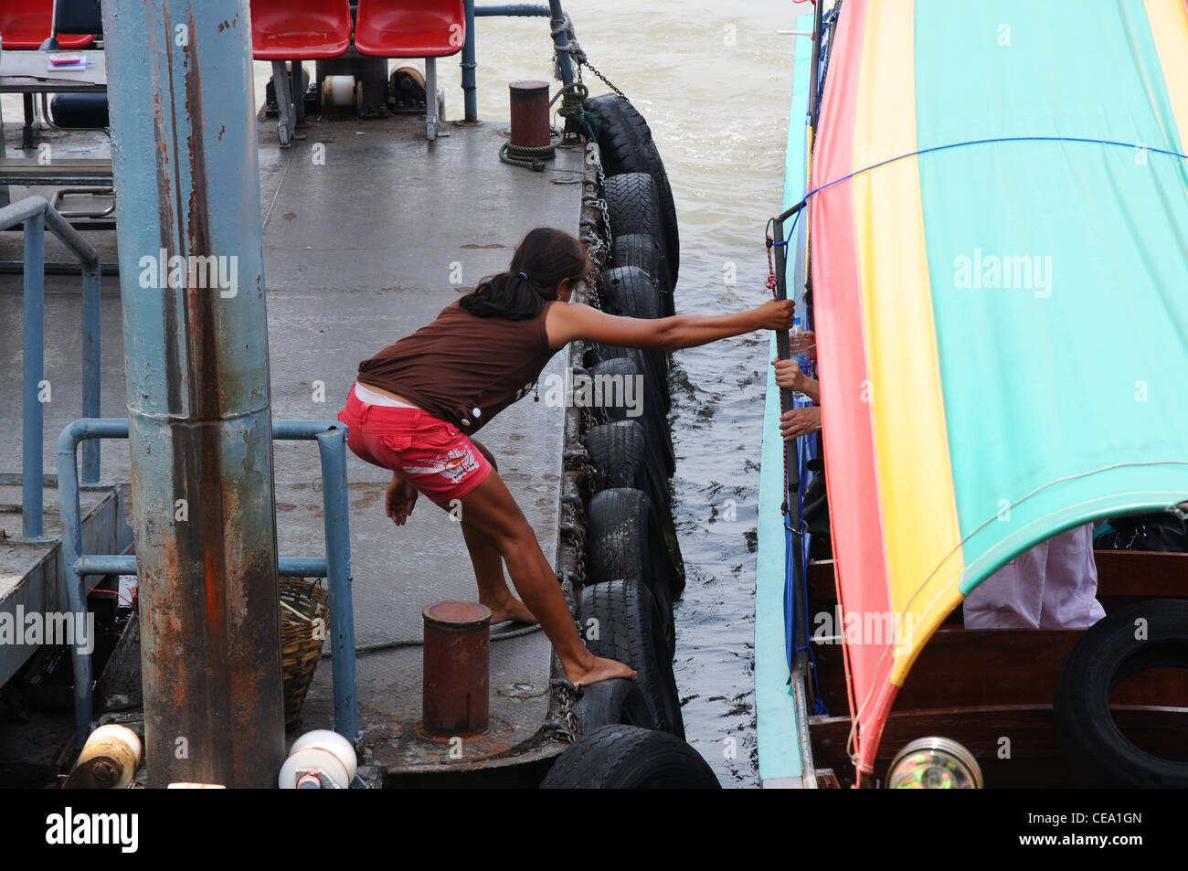 Thai Mädchen zieht Longtail-Boot Pier, Chao Phraya River, Bangkok, Thailand Stockfoto