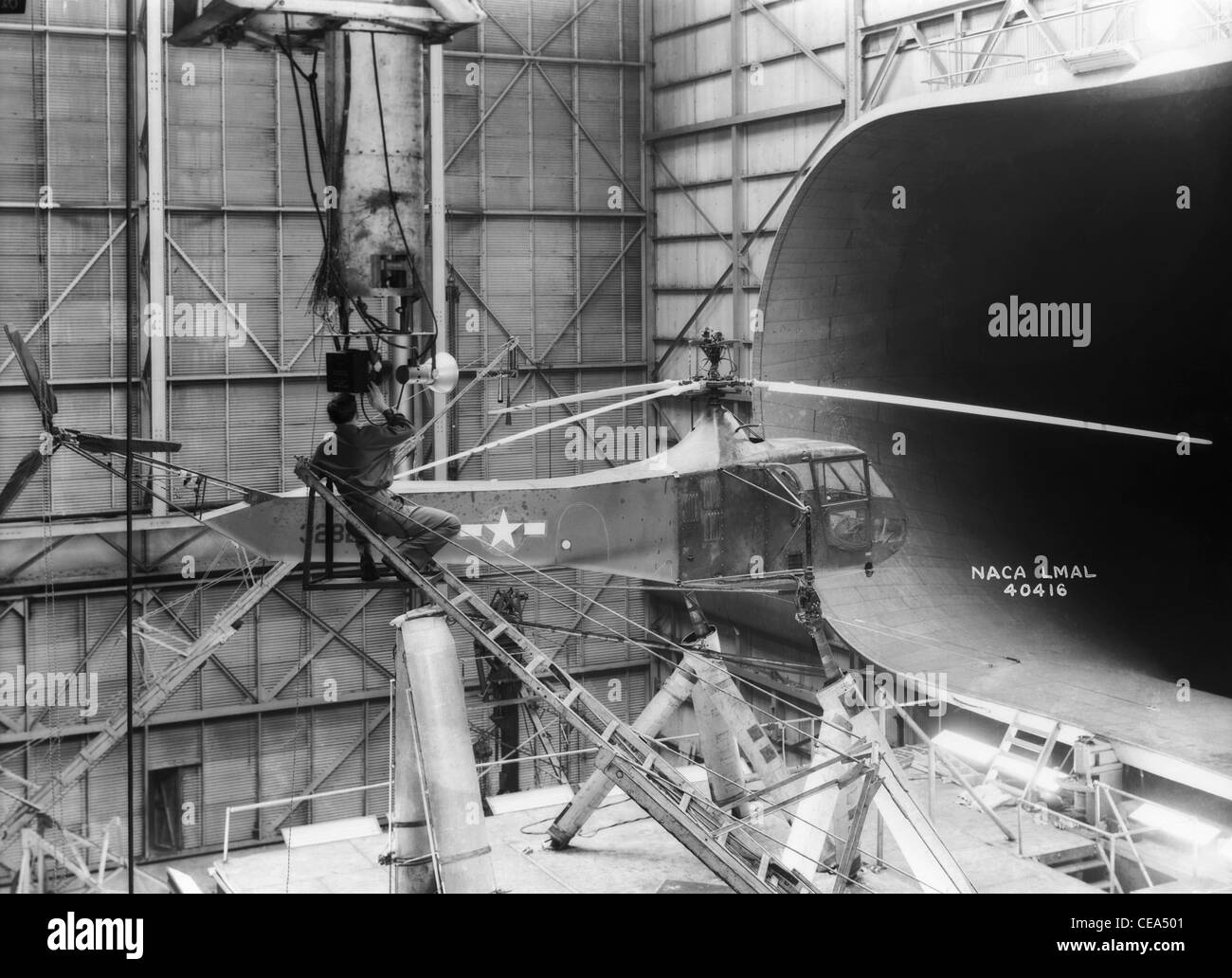Sikorsky-Hubschrauber In dieser Aufnahme im Jahr 1944 einer der Langley Research Center Sikorsky YR-4 b/HNS-1 Hubschrauber ist in 30 x 60 Full Scale Tunnel zu sehen. Ein Techniker richtet ein Kamera-Ausrüstung für Stop-Aktion Rotorblatt Fotos. Sikorsky baute hunderte von r-4 Hubschrauber während des zweiten Weltkriegs. Es war der erste massenproduzierte Hubschrauber. Bild-Gutschrift: NASA Stockfoto