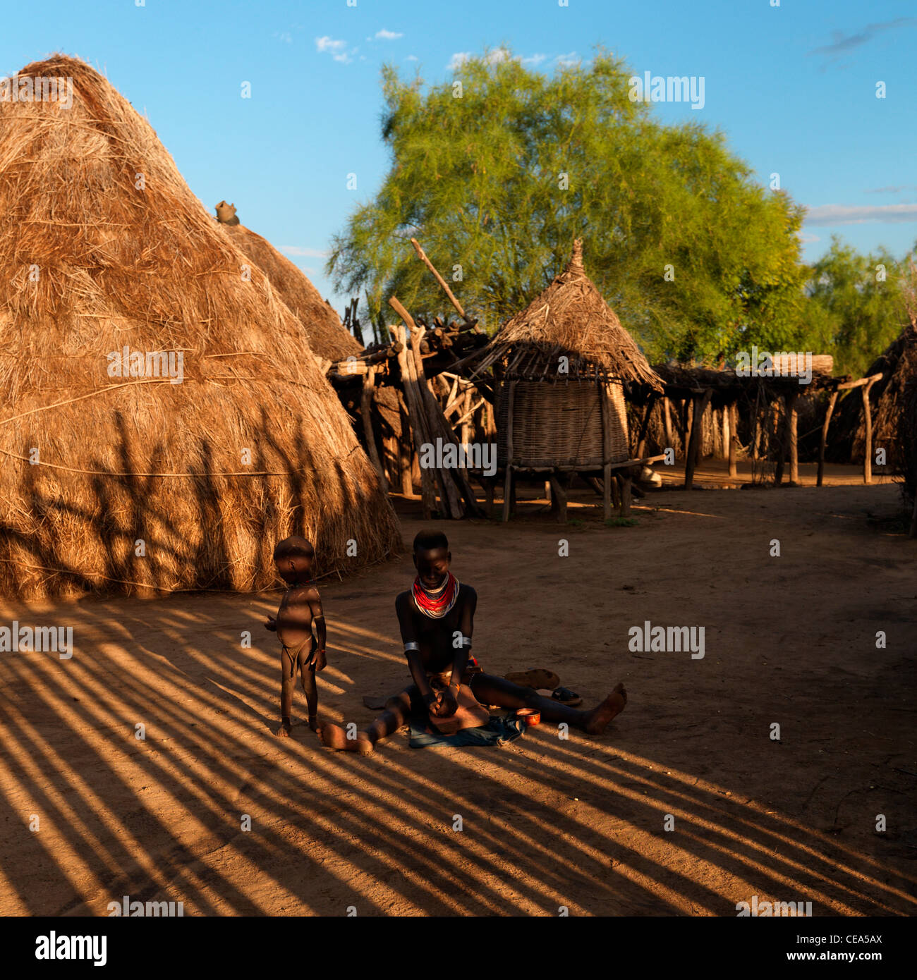 Karo-Frau und Kind sitzen in der Mitte Karo-Hütten-Omo-Tal-Äthiopien Stockfoto