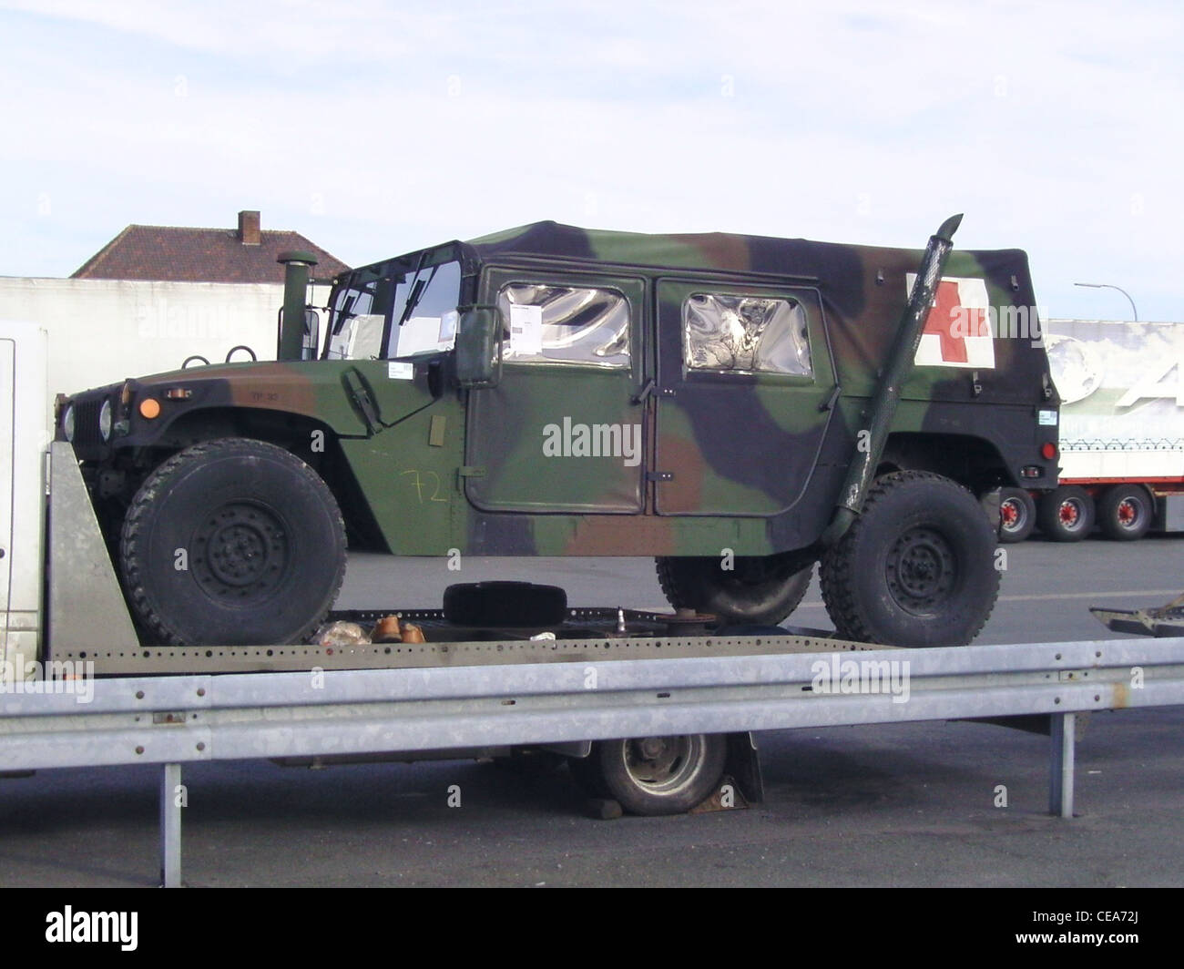 Ein Humvee mit dem Roten Kreuz ist in einem deutschen Hafen zu sehen, was seinen Einsatz in humanitären Missionen symbolisiert. Diese Fahrzeuge werden häufig von Militär- oder Notfallteams in Krisengebieten eingesetzt, um bei Katastrophen Hilfe und Hilfe zu leisten. Stockfoto