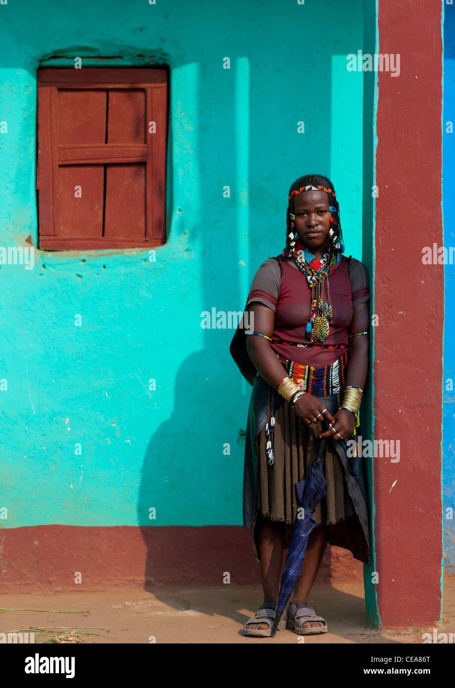 Traditionelle Kleidung Ara Woman Posing Außenseite des blauen Hauses In Jinka Omo-Tal-Äthiopien Stockfoto