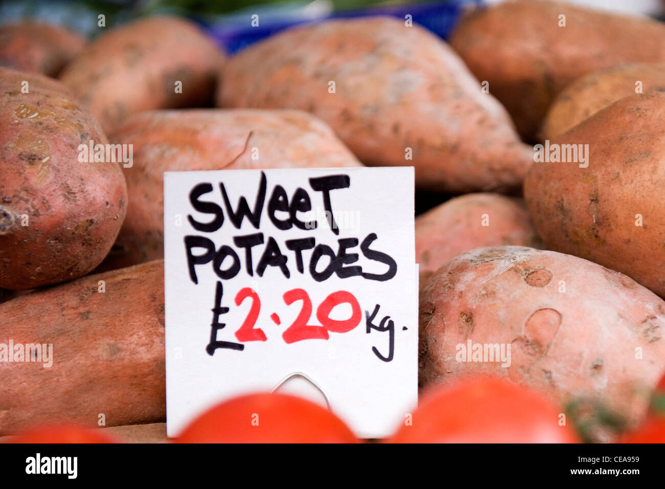 Borough Market London Gemüse shop shop Gemüsehändler Süßkartoffeln Stall mit Preis £ 2,20 pro kg Stapel Tomate Stockfoto