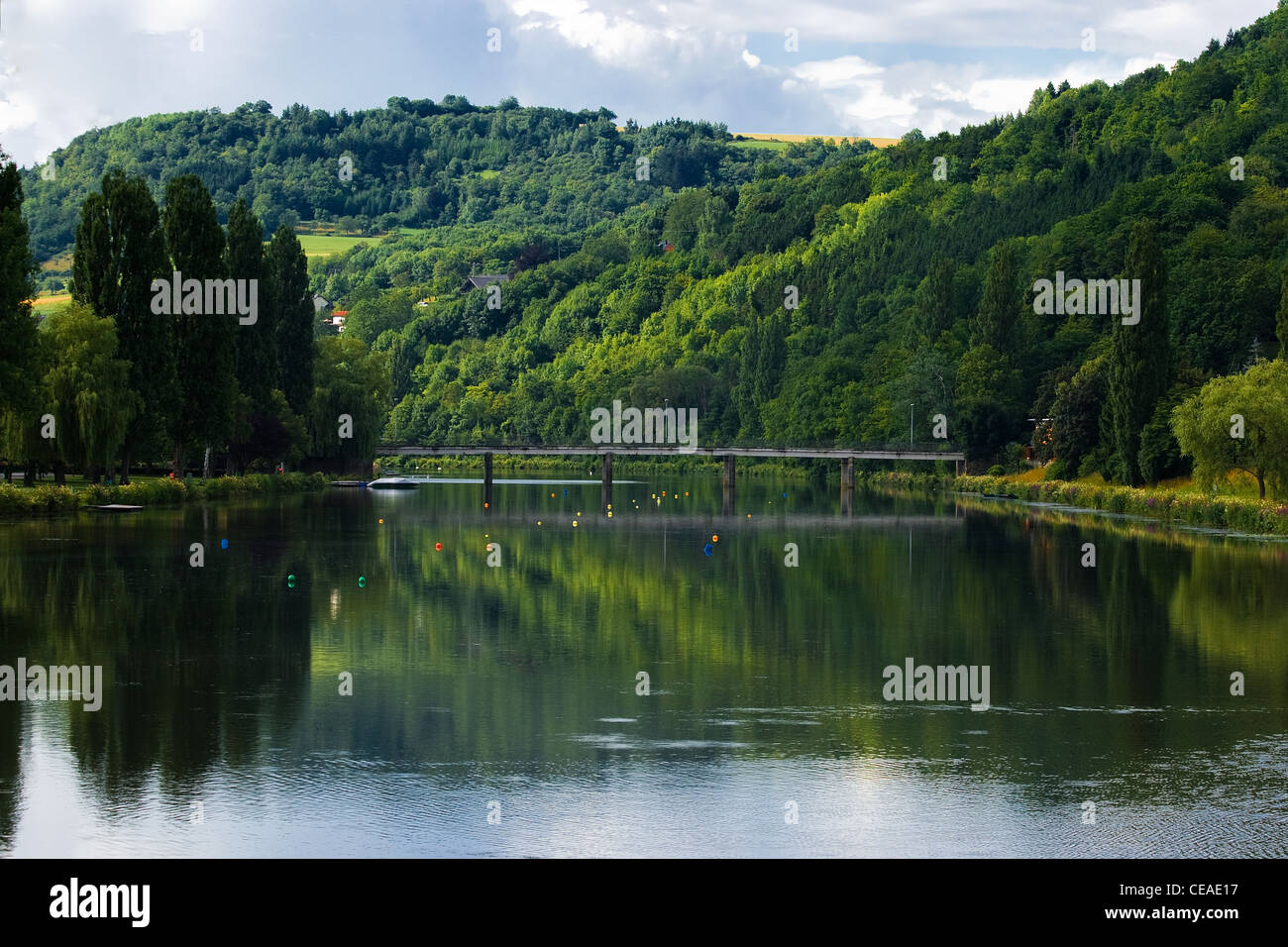 Landschaft in Luxemburg - Hügel, Wald und Brücke mit Spiegelbild im Fluss im Sommer Stockfoto
