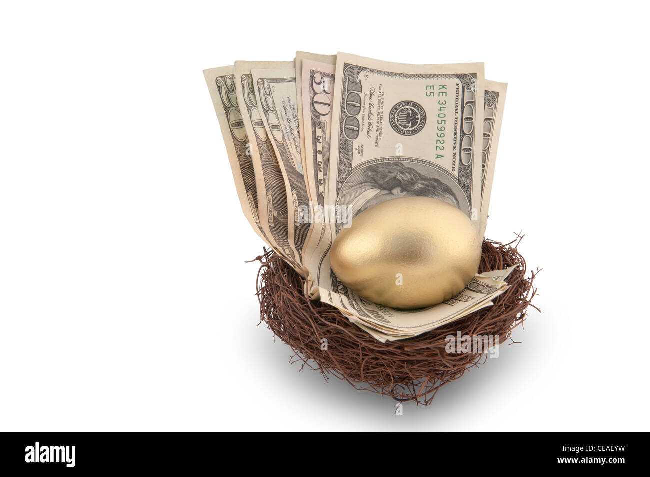 Ein goldenes Ei in ein Nest voller Bargeld einschließlich einer Rechnung $100 und $50 sitzen Stockfoto