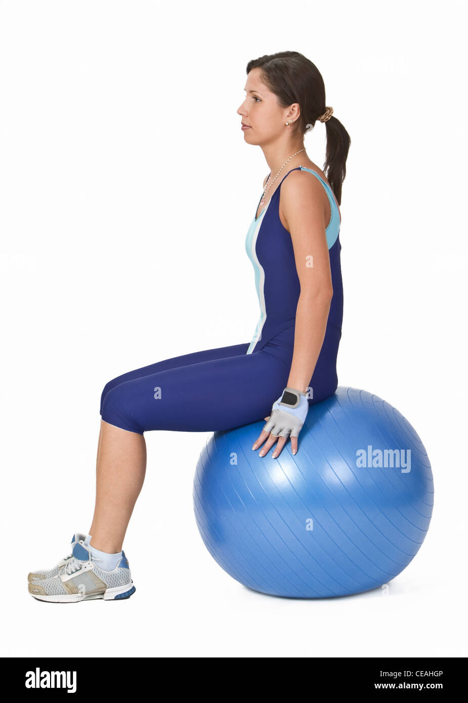 Junge aktive Frau sitzt auf einem blauen Fitnessball Stockfoto