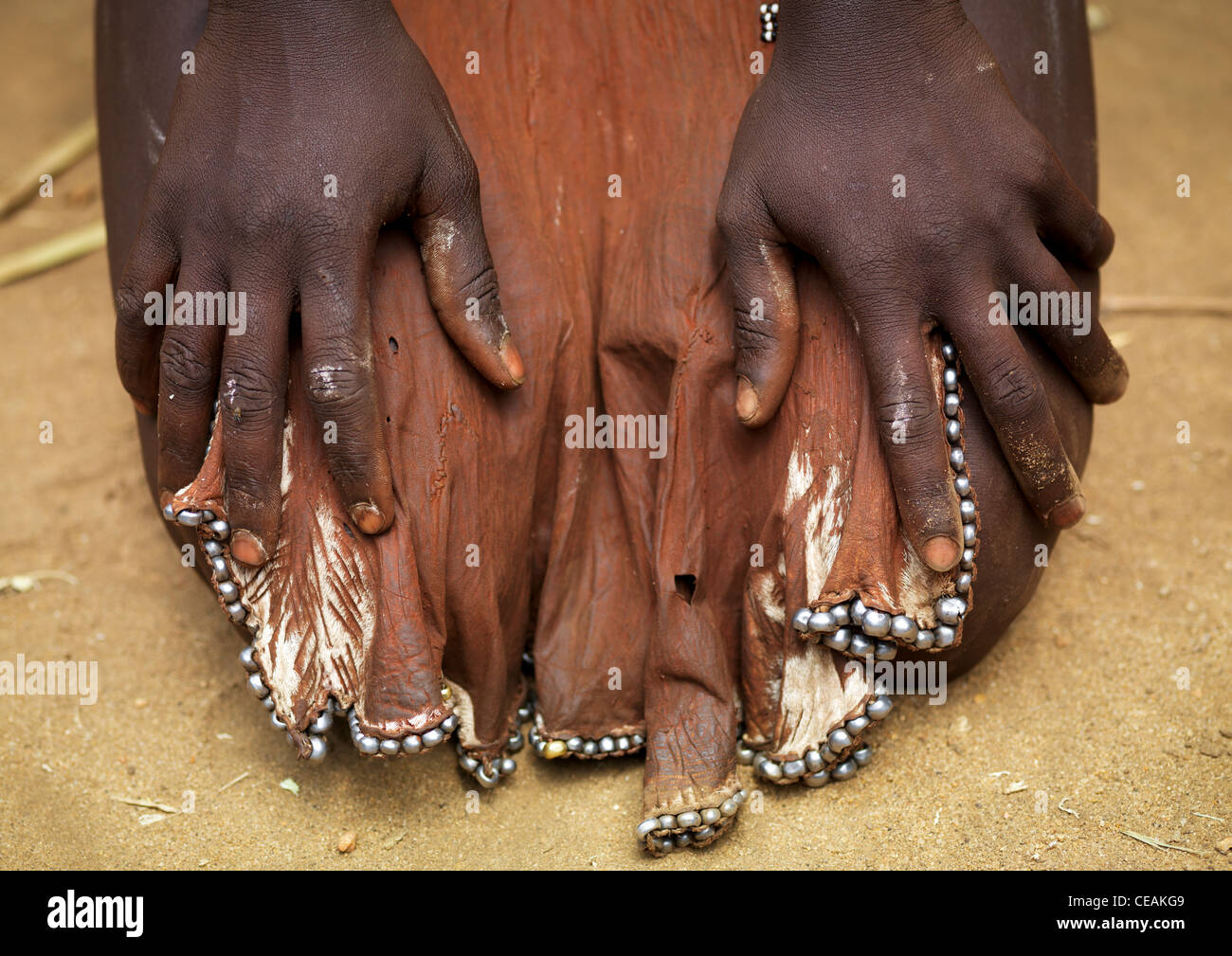 Heiligenbild Karo-Frau mit Haut Lendenschurz und Hand über ihre Beine-Äthiopien Stockfoto