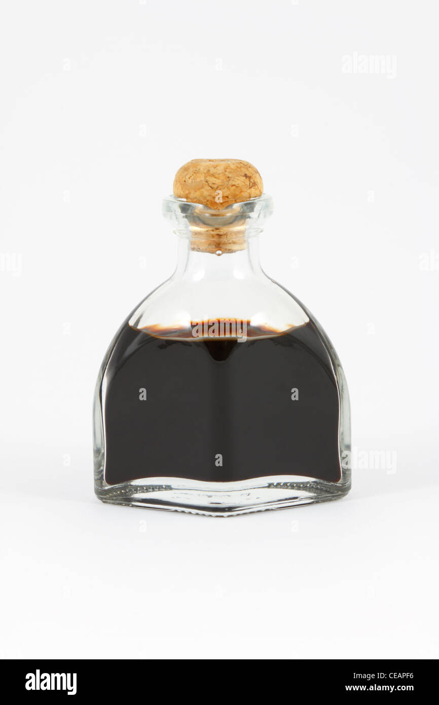 Balsamico-Essig in eine Glasflasche mit einem Korken auf weißem Hintergrund. Stockfoto