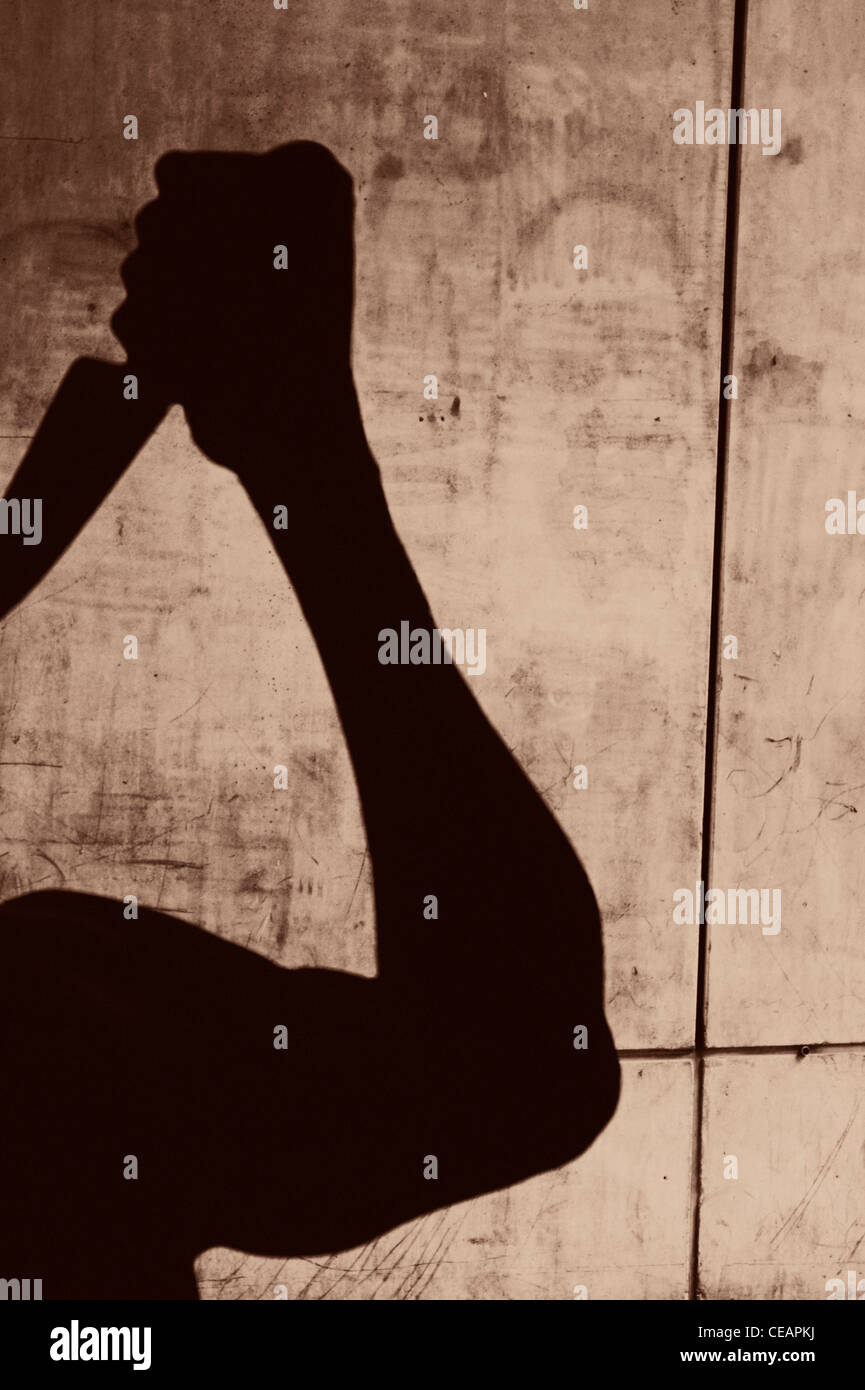 Silhouette der Mann mit einem Messer in einem städtischen Umfeld Stockfoto