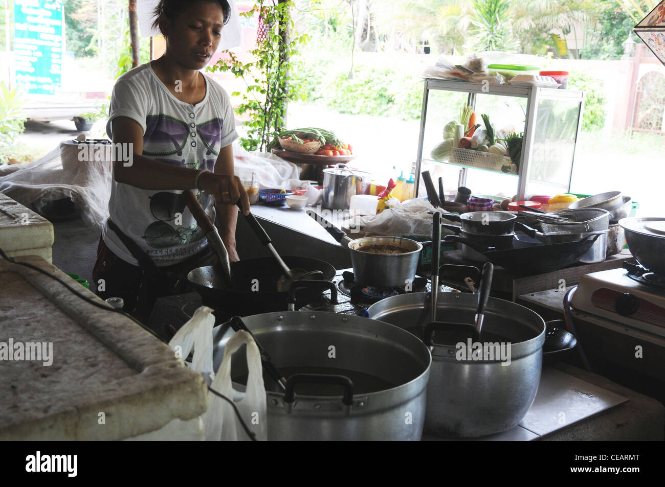 Thai Mädchen Kochen in Raststätte, Kanchanaburi, Thailand Stockfoto