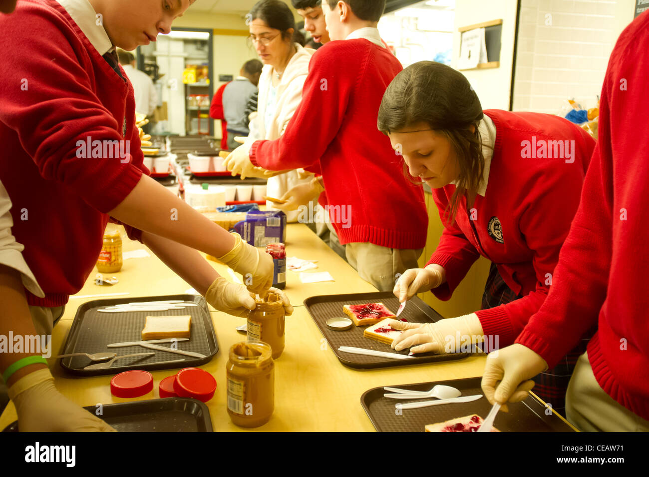 Siebte und Achtklässler Erdnussbutter und Gelee Sandwiches für bedürftige Stockfoto