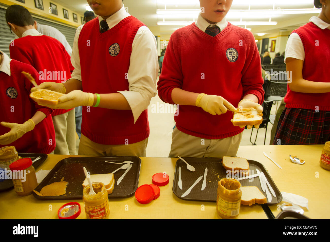Siebte und Achtklässler Erdnussbutter und Gelee Sandwiches für bedürftige Stockfoto