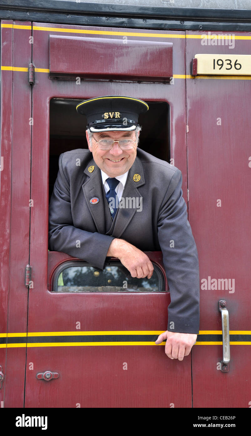 Steam Train-Dirigent aus Passagier Autofenster gelehnt Stockfoto