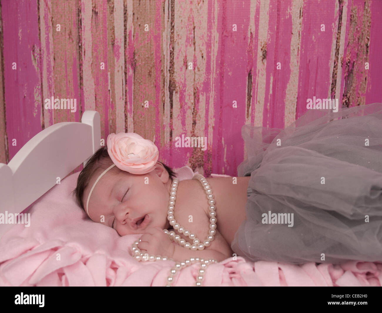 Schöne neugeborenen Mädchen mit rosa geblümten Stirnband, grau Tutu und Perlen, ist sie eingeschlafen sound. Stockfoto