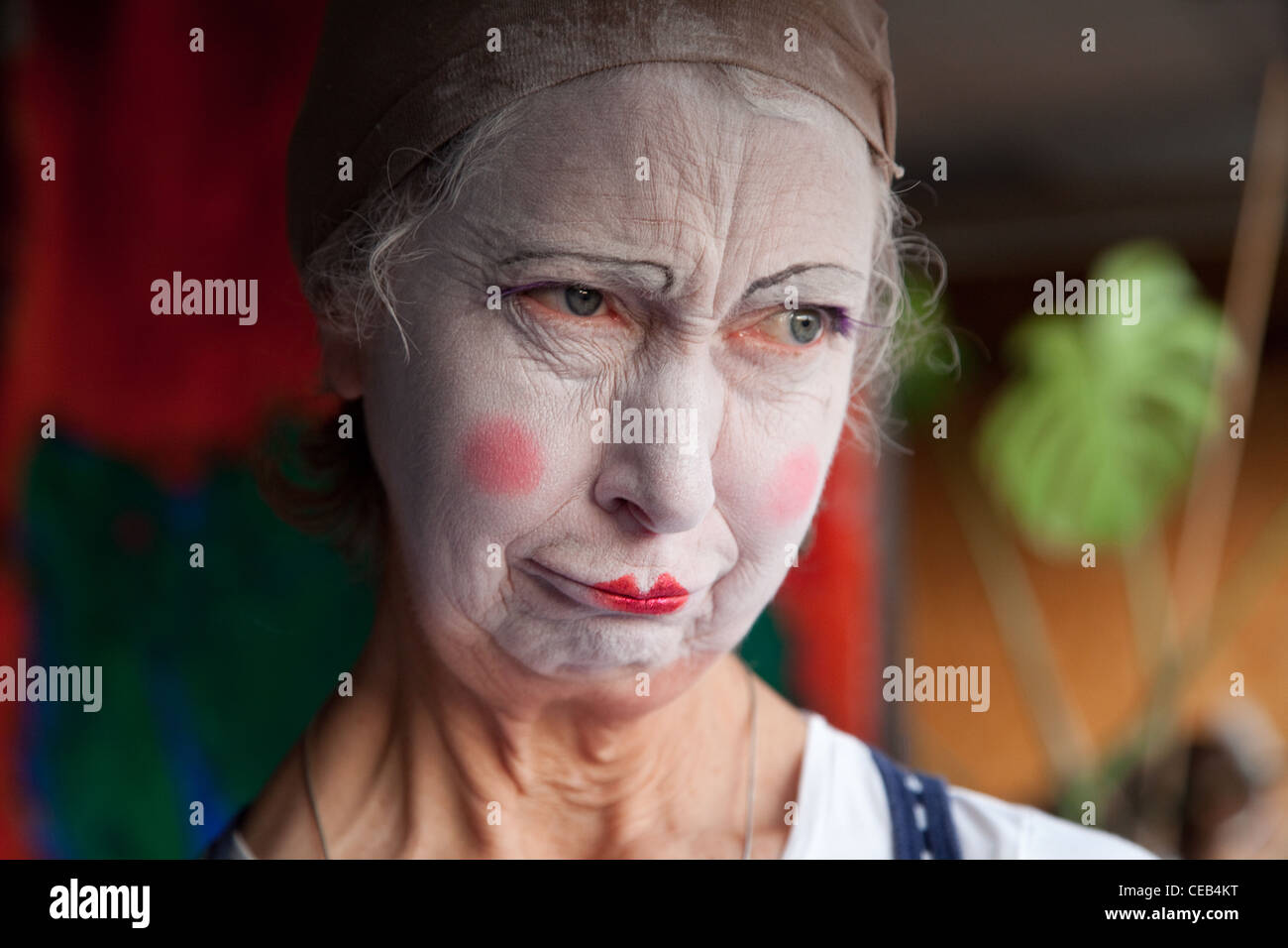 Seniorin im Whiteface Clown Make-up zieht eine Reihe von lustigen Gesichtern. Bild 7 von 8 Stockfoto