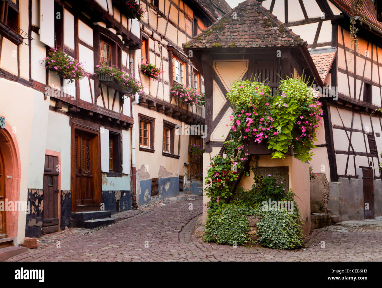 Malerische Straße mit mittelalterlichen Fachwerkhäusern in Eguisheim Dorf entlang der berühmten Weinstraße im Elsass/Frankreich Stockfoto