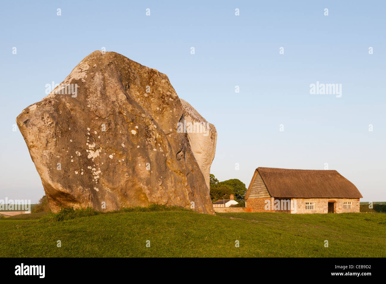 Stehenden Stein und eine Scheune am Abend, Avebury, Wiltshire Stockfoto