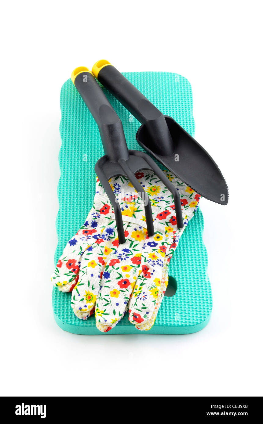 Kniend, Pad, Handschuhe und Hand Gartengeräte auf weißem Hintergrund in Hochformat Stockfoto