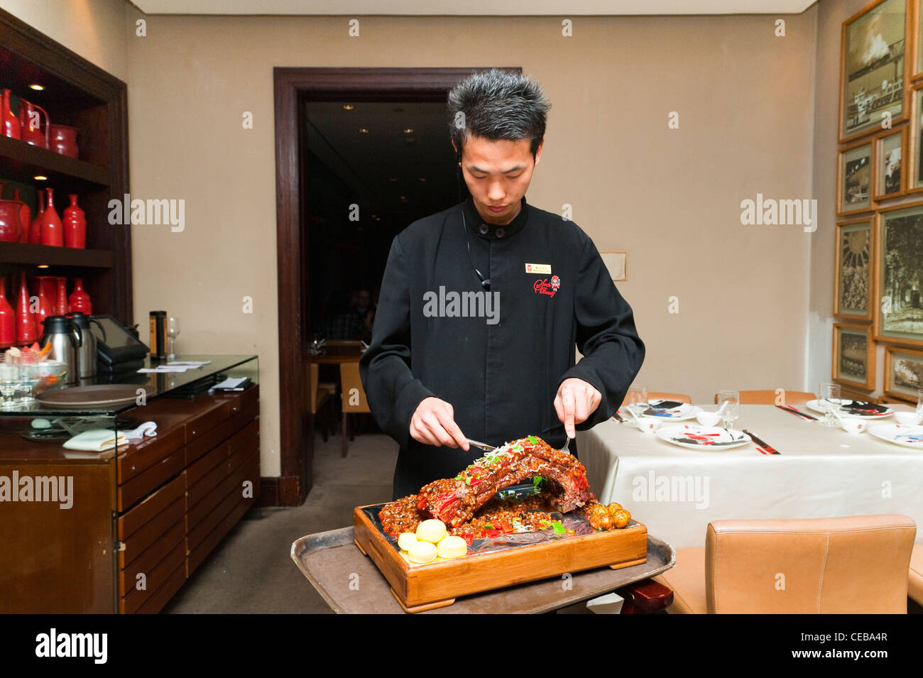 Kellner schneiden Schweinefleisch Rippen, Sichuan Küche Restaurant, Haiyongxiang District, Shanghai, China, Asien. Stockfoto