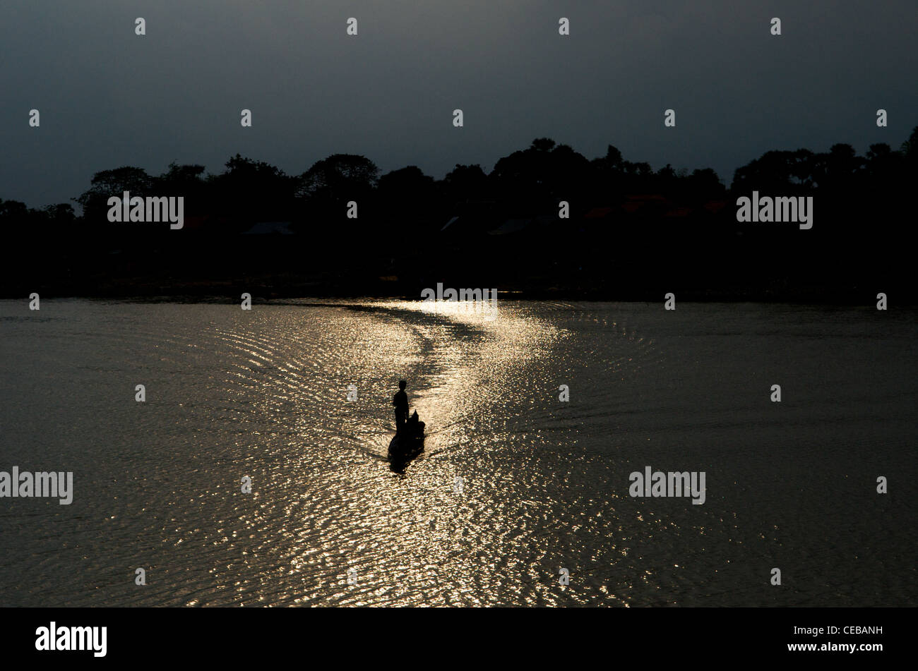Khmer Mann auf Boot bei Sonnenuntergang, gestochen Sen Fluss, Kampong Thom Provinz, Kambodscha, Indochina. © kraig Lieb Stockfoto