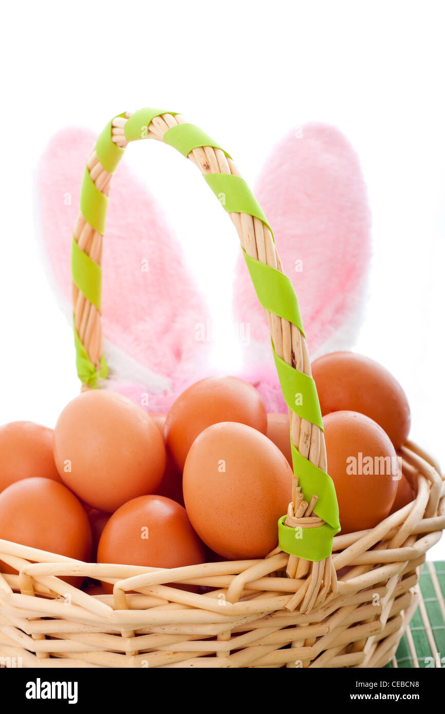 Detail der Osterkorb mit Eiern und Hasenohren, isoliert auf weißem Hintergrund. Stockfoto
