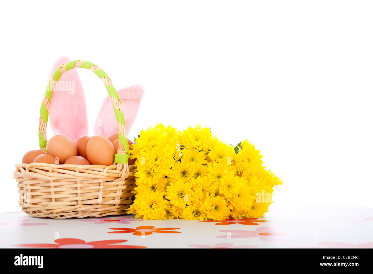 Osterkorb mit Eiern, Blumen und Hasenohren, Ostern-Hintergrund mit Textfreiraum, isoliert auf weißem Hintergrund. Stockfoto