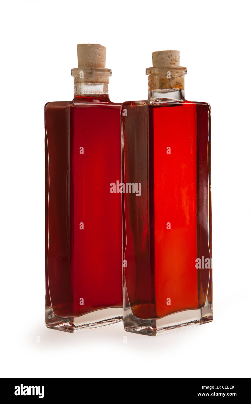 zwei Glasflaschen auf einem weißen Hintergrund mit roten braune Flüssigkeit Stockfoto