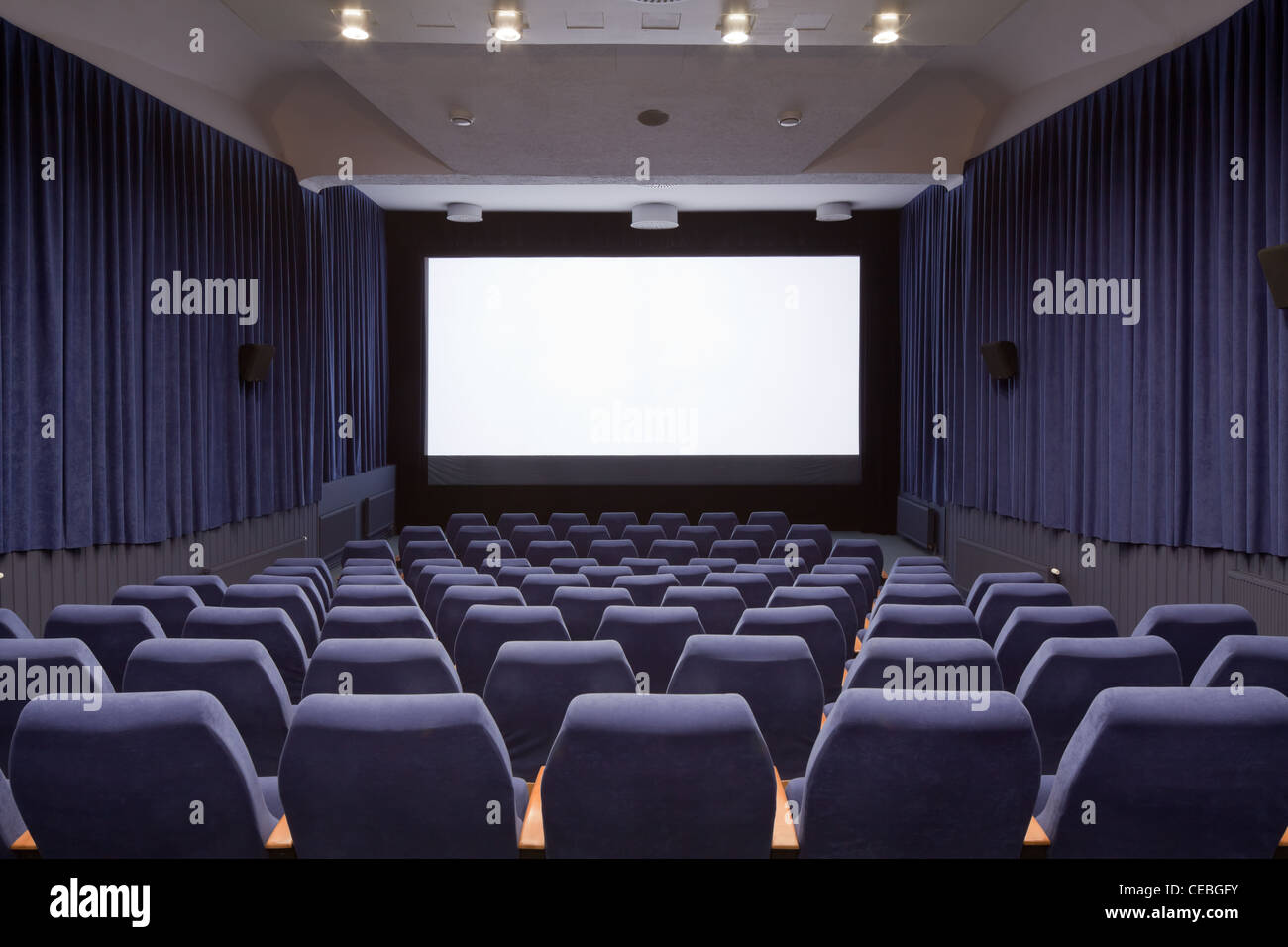 Leeren Kinosaal mit Stühlen und Projektionsfläche. Bereit für Ihr eigenes Bild hinzufügen. Ansicht von vorne. Stockfoto