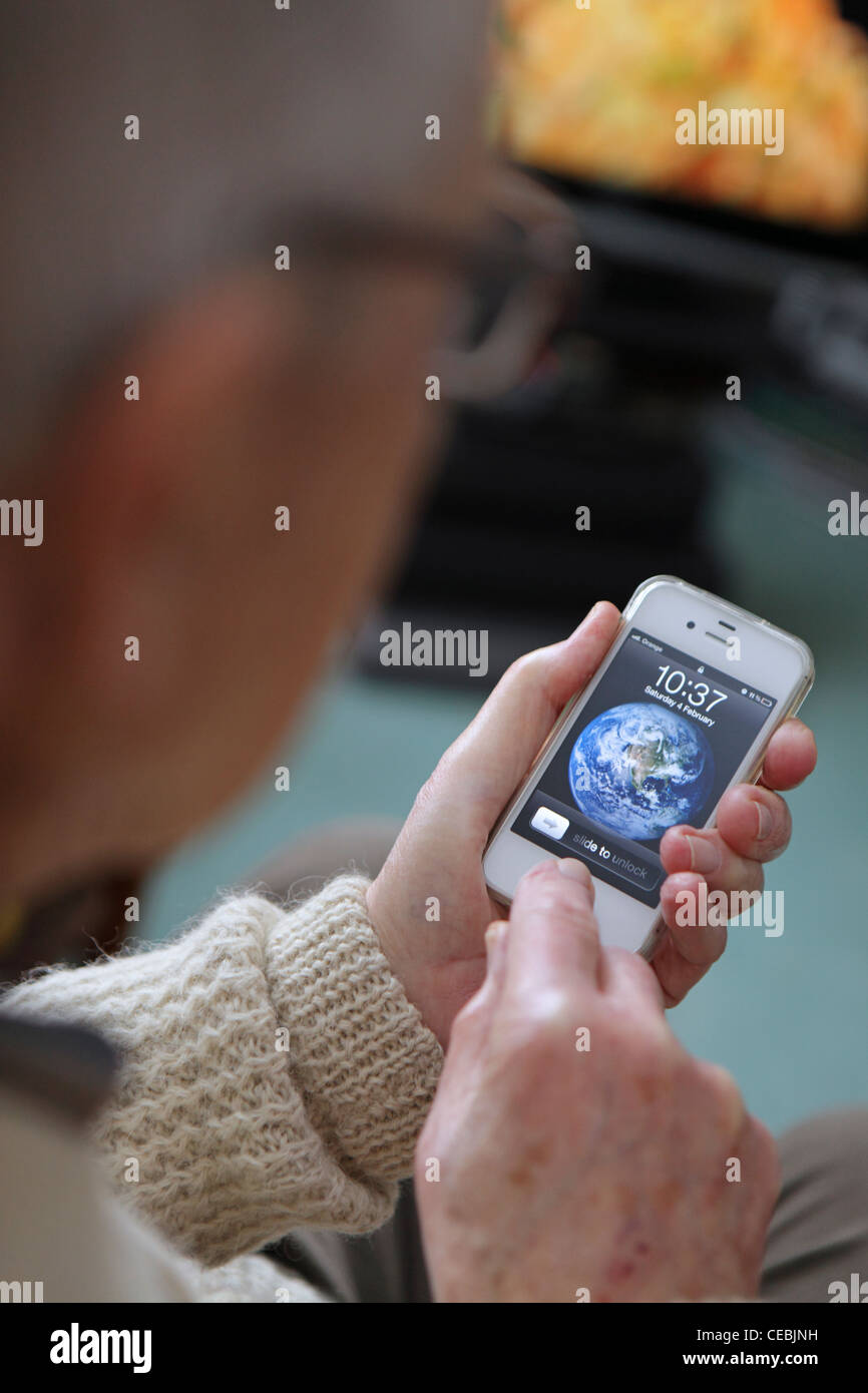 ältere ältere Mann Annahme mit neuen Technologie, iPhone 4 s, Smartphone, intuitiven Touchscreen zu Hause genießen Stockfoto