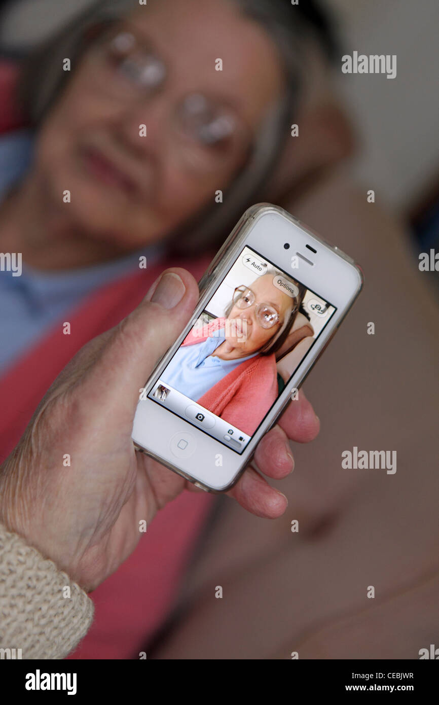 älteres Ehepaar verwenden iPhone, um Familie zu fotografieren, Benutzer-freundlichen Touch-Screen-Technologie zur Kommunikation mit Familie zu genießen Stockfoto
