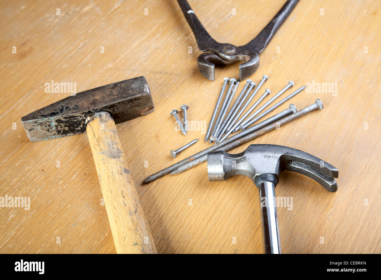 Hammer, Nägel und Zange auf einem Holztisch Stockfoto