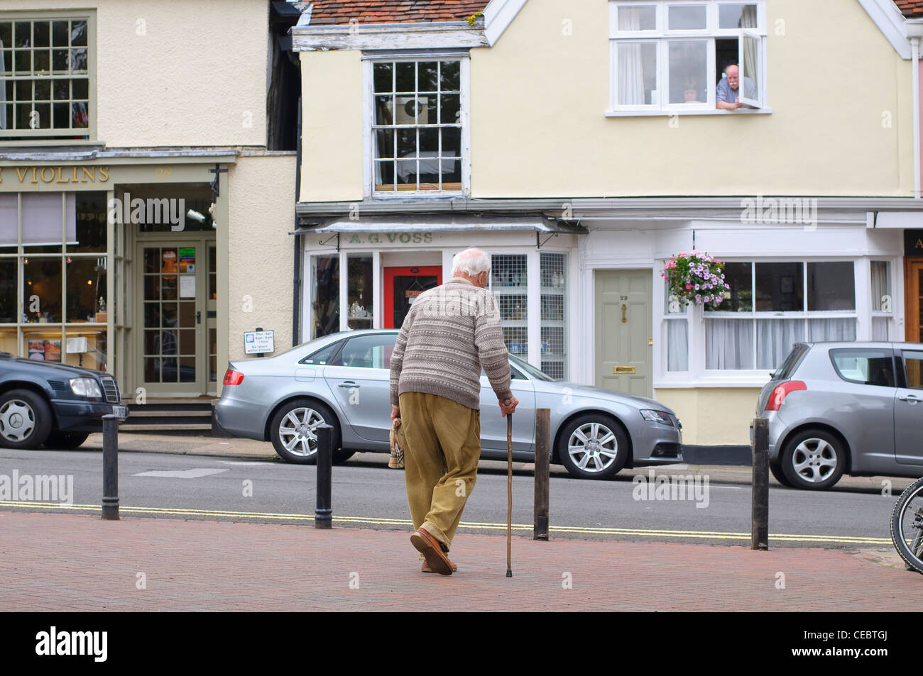 Älterer Mann mit Stock im Markt Hill, Woodbridge, Suffolk, UK Stockfoto