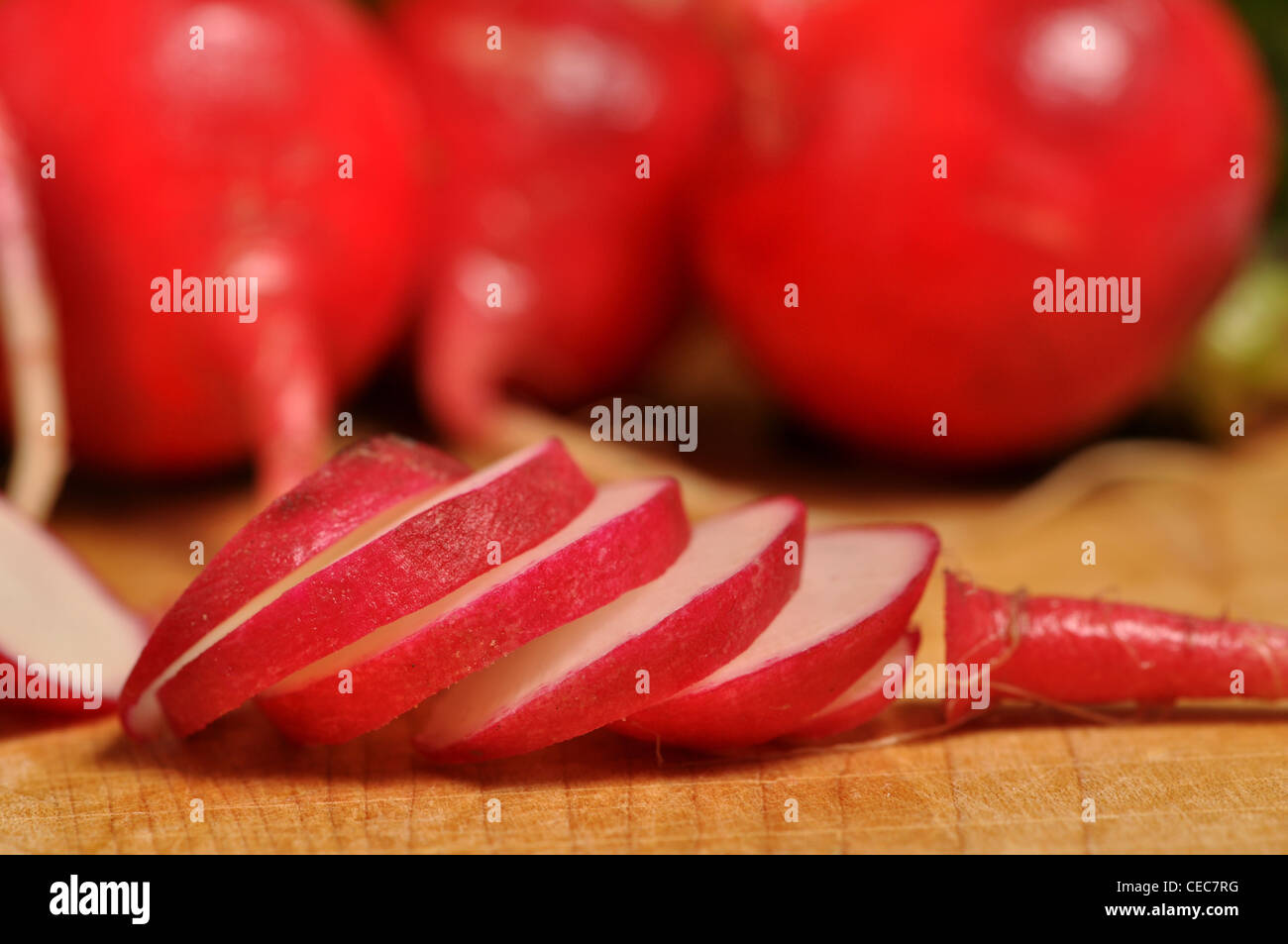 Eine in Scheiben geschnittene Radieschen Verlegung auf einem Holzbrett. Stockfoto