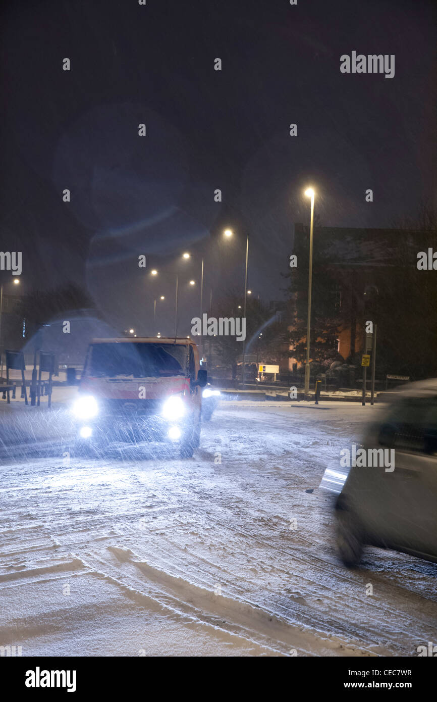 Van mit Licht fahren um einen Kreisverkehr bei winterlichen/Schnee Wetter bei Nacht Stockfoto