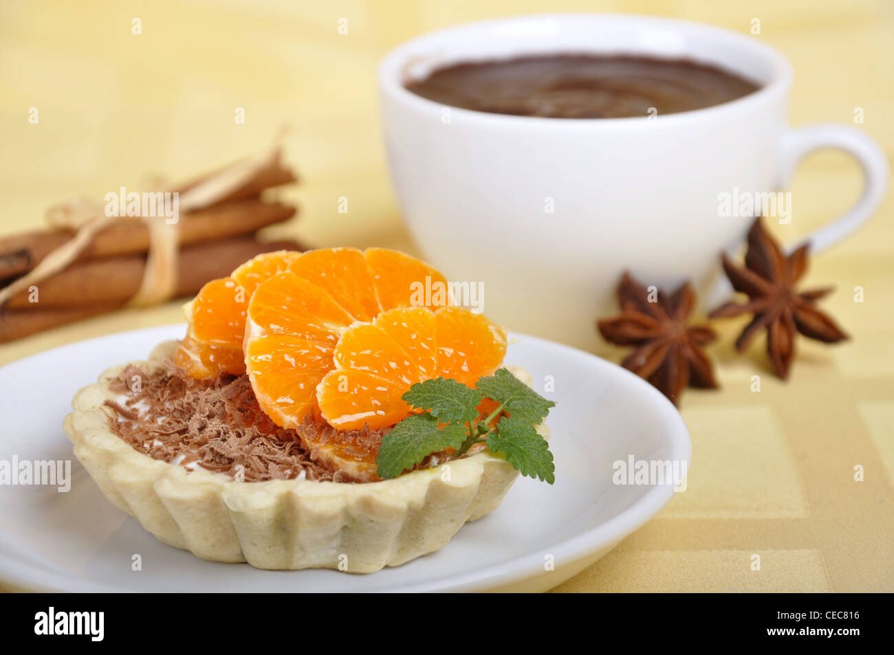 Hausgemachte Kuchen mit frischem Orange, Minze und Tasse heißen chokolate Stockfoto